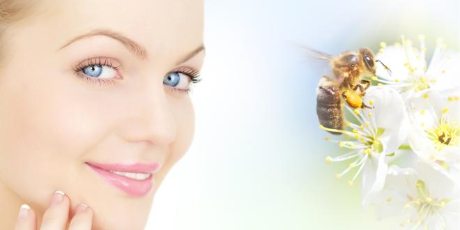 a woman with healthy skin thanking a bee for its products